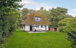a thatch roofed house with a grass yard at 2 Bedroom Beautiful Home In Ringe in Ringe