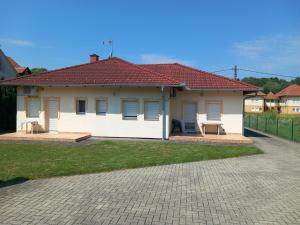 a small white house with a red roof at Petra Apartmanház in Kehidakustány