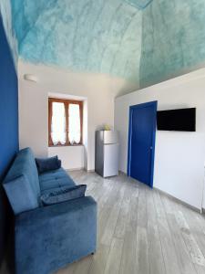 Casale Forno Vecchio في ترامونتي: غرفة معيشة بها أريكة زرقاء وباب أزرق