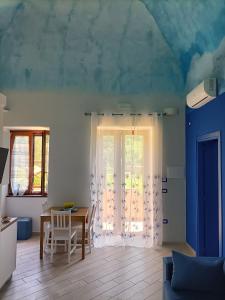 een woonkamer met een tafel en een raam bij Casale Forno Vecchio in Tramonti