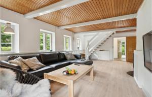 ein Wohnzimmer mit einem schwarzen Sofa und einem Tisch in der Unterkunft Pet Friendly Home In Vejle With Kitchen in Vejle