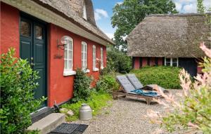 a red house with a bench in front of it at Pet Friendly Home In Vejle With Kitchen in Vejle