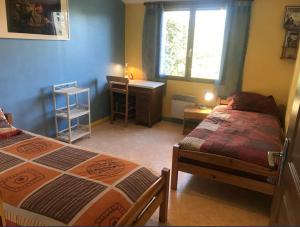 a bedroom with two beds and a desk and a window at Maison Indépendante 3étoiles avec grand jardin in Saint-Germain