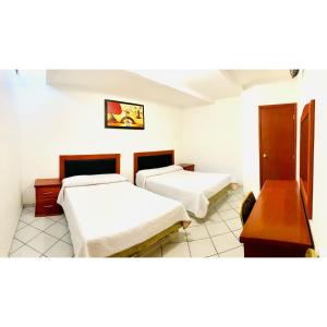 um quarto com três camas e uma mesa em Posada Mi Rey em Guadalajara