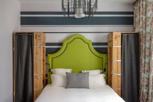 a bedroom with a bed with a green headboard at Hôtel Fabric in Paris