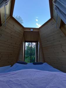 Cama en habitación de madera con ventana grande en Aurora Cone en Kiruna