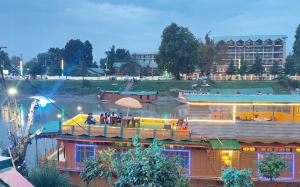 people sitting at a bar on a boat on a river at Houseboat Karima palace in Srinagar