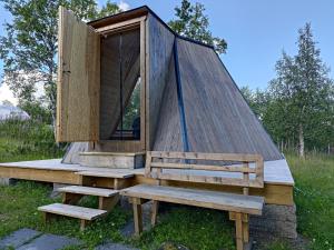 ein winziges Haus mit einer Tür und einer Bank in der Unterkunft Aurora Cone in Kiruna
