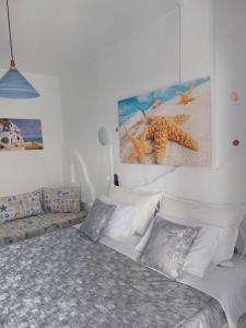 ein Schlafzimmer mit einem Bett und einem Sofa und einem Gemälde in der Unterkunft Doron Hotel Delfini in Naxos Chora
