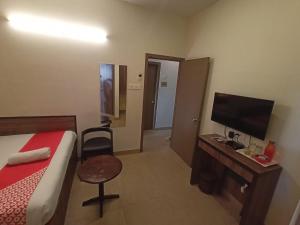 a hotel room with a bed and a desk with a television at HOTEL INDIANA in Shillong