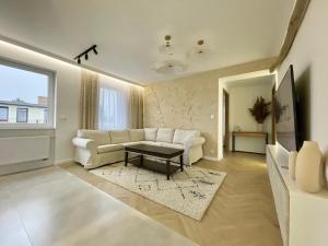 Una sala de estar con un sofá blanco y una mesa. en BALi 22, en Ustronie Morskie