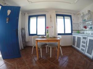 a kitchen with a table and chairs and a blue door at Ventanas de Lanzarote in Playa Quemada