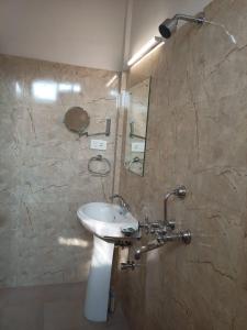 HOTEL INDIANA في شيلونغ: حمام مع حوض ومرآة