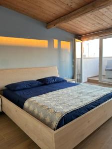 a bedroom with a bed with blue sheets and a window at B&B Casa CamiLory in San Lucido