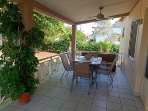 un patio con tavolo e sedie sul balcone. di Calda Ospitalita a Néa Karyá