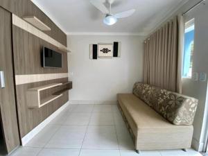 ein Wohnzimmer mit einem Sofa und einem TV in der Unterkunft Lacqua Diroma - parque 24H in Caldas Novas