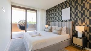 a bedroom with a large bed and a window at Modern and Spacious 1BR in Gaia by LovelyStay in Vila Nova de Gaia