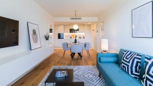 a living room with a blue couch and a table at Modern and Spacious 1BR in Gaia by LovelyStay in Vila Nova de Gaia