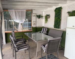 un patio con tavolo in vetro e sedie di House Varna-4 a Krapets