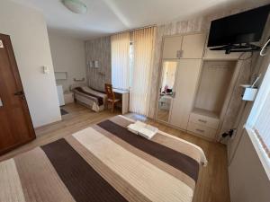 Habitación de hotel con cama y sofá en House Varna-4, en Krapets