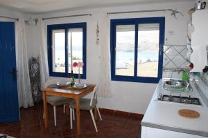 a kitchen with a table and a stove and windows at Ventanas de Lanzarote in Playa Quemada