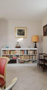 a living room with a book shelf filled with books at Mare è Monte , jardin méditerranéen et exotique. in Ghisonaccia