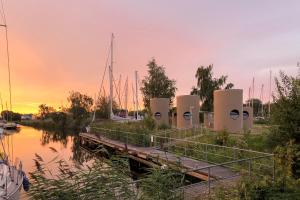 ein Dock mit Booten in einem Yachthafen bei Sonnenuntergang in der Unterkunft slube am Yachthafen Greifswald in Greifswald