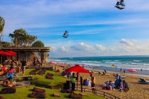 a group of people on a beach with people flying kites at Selog Villa 4 in Seminyak