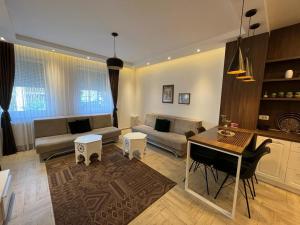 sala de estar con sofá y mesa en Golden Gate Apartment Sarajevo en Sarajevo