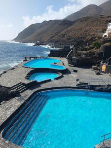 una fila de piscinas junto al océano en Alma y Sol en La Caleta