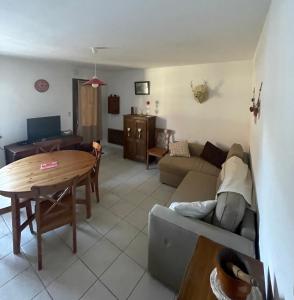 Appartement chalet 4 pers 45m2 Puy Saint Vincent في بوي-سانت-فينسينت: غرفة معيشة مع أريكة وطاولة