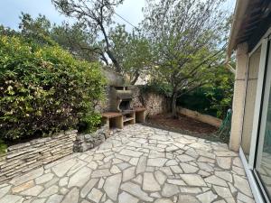 une terrasse en pierre avec un banc à côté d'un bâtiment dans l'établissement Maison rénovée proche des plages, à Sète