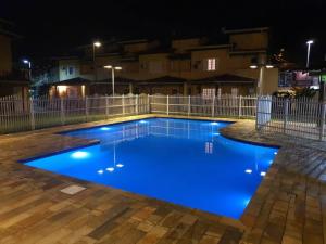 uma piscina à noite com iluminação azul em Casa em Paraty - RJ Cond. Fechado em Paraty