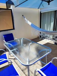 a glass table and chairs on a boat at Costa Terrace in Costa da Caparica