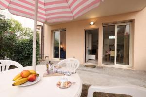 uma mesa com um prato de frutas e um guarda-chuva em We Home - PALESTRINA17 - Riccione sul mare em Riccione