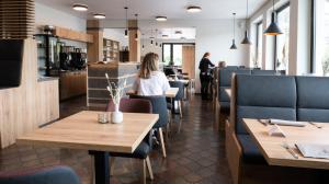 ジンメラートにあるHotel Paulushofの木製テーブルと青い椅子が備わるレストラン
