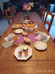a wooden table with plates of food on it at les tonneaux de Lisores in Lisores
