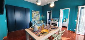 a dining room with blue walls and a table and chairs at TramontanaBeach in Tracino