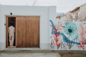 een gebouw met een deur met een schilderij aan de muur bij El garage in Esquel