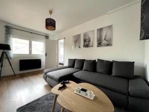 a living room with a couch and a coffee table at Le grand morétain in Moret-sur-Loing