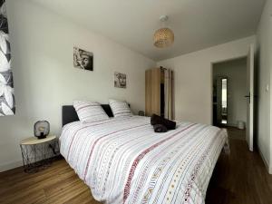 a bedroom with a large bed with a black cat laying on it at Le grand morétain in Moret-sur-Loing