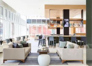 a living room with two couches and a bar at AC Hotel by Marriott Oklahoma City Bricktown in Oklahoma City