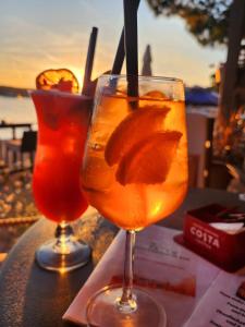 two drinks on a table with the sunset in the background at Old Town Arbia in Rab