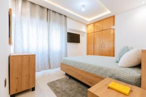 Un dormitorio con una cama y un armario de madera. en Najmat chamal malabata Tanger, en Tánger