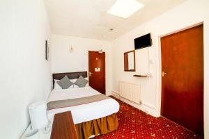 um quarto com uma cama e um tapete vermelho em OYO The Golden Cheval Hotel & Shisha Bar em Blackpool