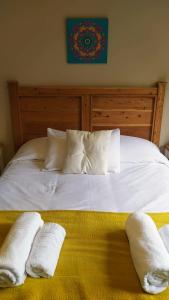 a white bed with two white towels on it at Andalue in San Carlos de Bariloche
