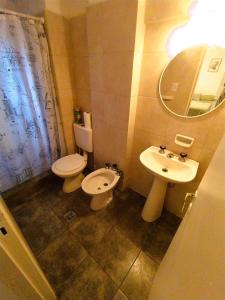 a bathroom with a sink and a toilet and a mirror at Departamento en el centro de Córdoba in Cordoba