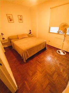 um quarto com uma cama e piso em madeira em Departamento en el centro de Córdoba em Córdoba