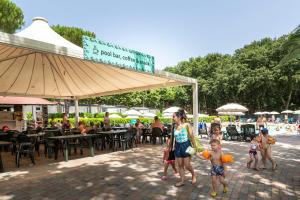 een groep kinderen die op een stoep in de buurt van een strand lopen bij hu I Pini village in Fiano Romano