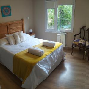 una camera da letto con un grande letto con due cuscini sopra di Andalue a San Carlos de Bariloche